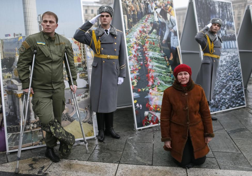 Một phụ nữ vừa khóc vừa quỳ xuống trong một buổi lễ an táng cho Gruzia Tomaz Sukhiashvili, 35 tuổi, một thành viên của tiểu đoàn tự vệ ‘Donbass’, người đã bị giết chết trong cuộc chiến đấu ở miền đông Ukraine, tại Quảng trường Độc lập ở trung tâm Kiev, ngày 21 tháng 1 năm 2015 . Thủ tướng Arseny Yatseniuk cho biết hôm thứ Tư. Đạo luật đang được chuẩn bị nhằm tăng qui mô của các lực lượng vũ trang Ukraine từ 68.000 người lên tới 250.000 người, REUTERS / Gleb Garanich
