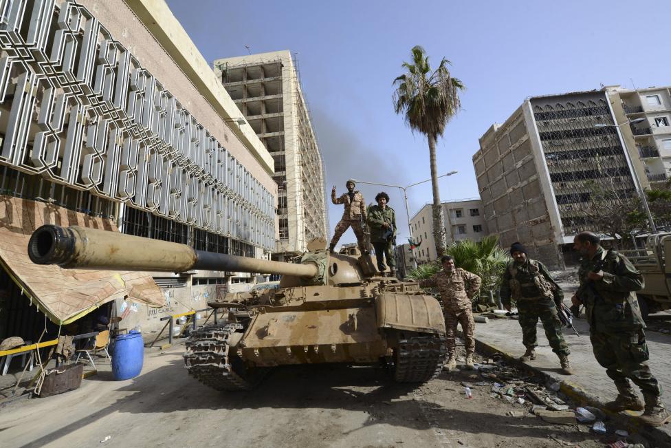 Các thành viên của lực lượng ủng hộ chính phủ Libya được hậu thuẫn bởi người dân địa phương, đã tập trung trên một chiếc xe tăng bên ngoài Ngân hàng Trung ương, gần cảng Benghazi, ngày 21 tháng 1, năm 2015. Khu vực này là hiện trường của trận đánh thảm khốc  chống lại  Hội đồng Shura của cách mạng Libya, một liên minh của quân nổi dậy chống Gaddafi cũ, người đã gia nhập lực lượng với nhóm Hồi giáo Ansar al-Sharia REUTERS / Esam Omran Al-Fetori