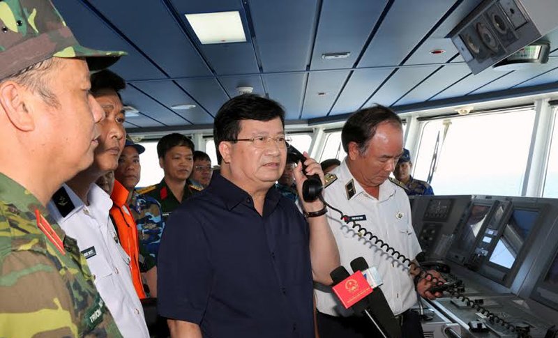Phó Thủ tướng Trịnh Đình Dũng gọi điện thăm hỏi, động viên lực lượng tìm kiếm trên các tàu tại hiện trường sáng 23/6. Ảnh VietNamNet