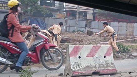Các chiến sĩ cảnh sát giao thông nhanh chóng dọn đất đá vương trên đường đảm bảo lưu thông