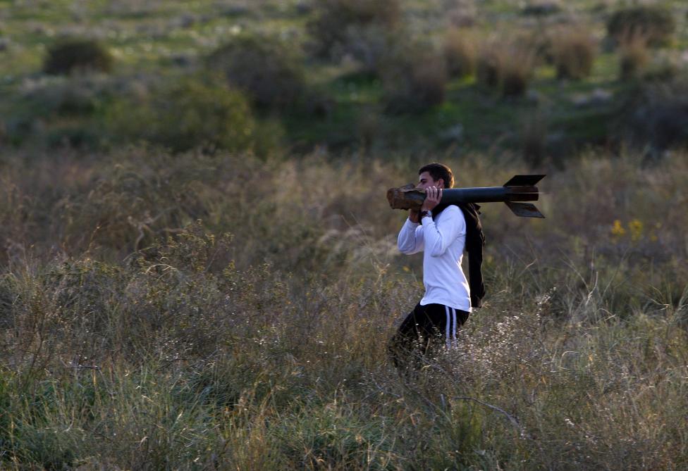 Một thanh niên người Israel đang vác trên vai xác quả tên lửa được phóng bởi lực lượng Palestine ở Gaza.