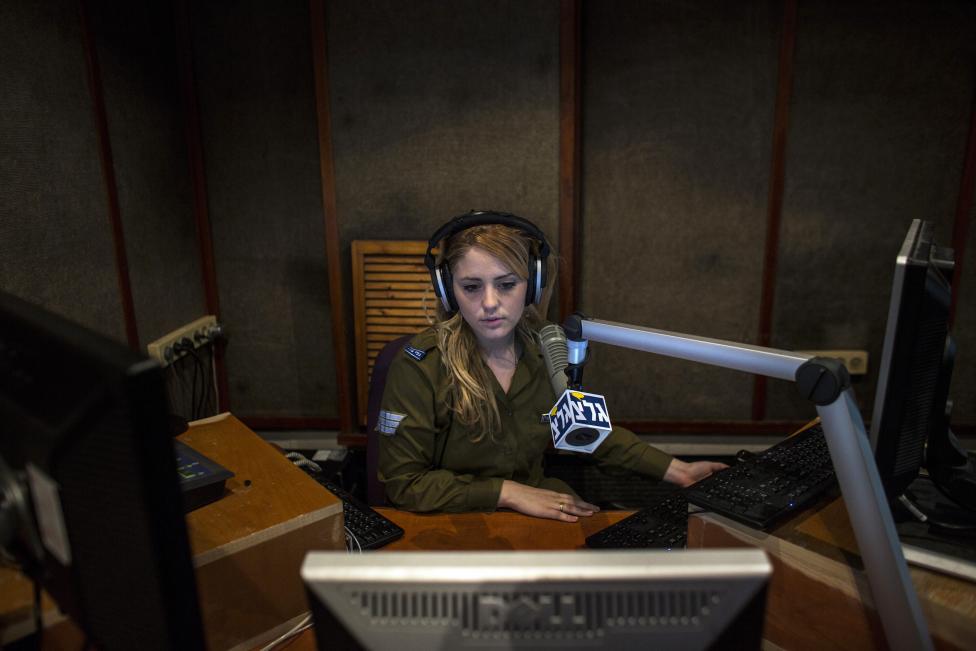 Nữ phát thanh viên của đài Galei Tzahal, một đài phát thanh quân sự của người Israel đang làm nhiệm tại phòng thu Jaffa, phía nam trung tâm Tel Aviv, Israel. Nguồn ảnh: REUTERS/ Nir Elias.