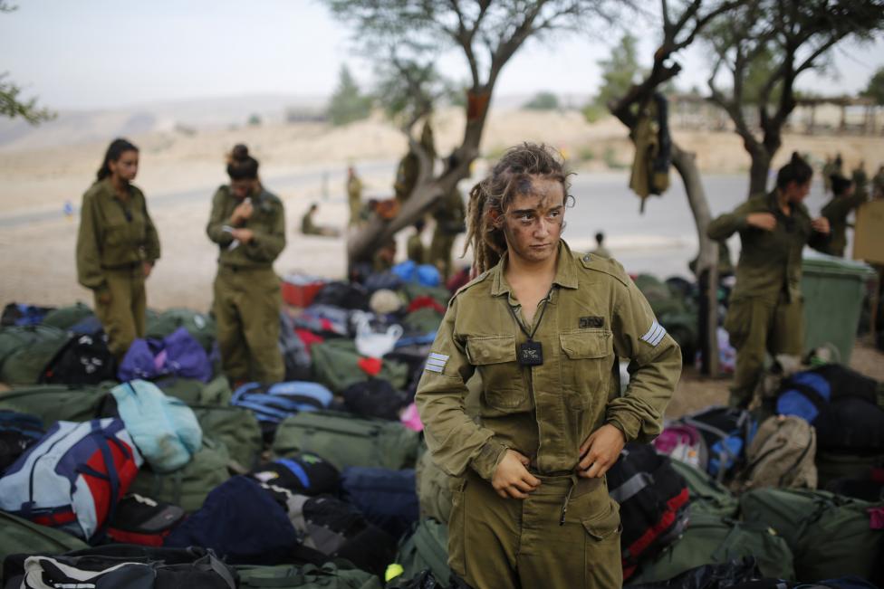 Một nữ quân nhân thuộc tiểu đoàn Caracal đứng bên cạnh một núi quân trang sau khi kết thúc cuộc hành quân 20 km ở hoang mạc Negev, gần Kibbutz Sde Boker. Tiểu đoàn Caracal được thành lập năm 2004 với 2/3 là nữ giới có nhiệm vụ tuần tra thường xuyên biên giới với Ai Cập để chặn đứng những kẻ xâm nhập và buôn lậu. Nguồn ảnh: REUTERS/ Amir Cohen.