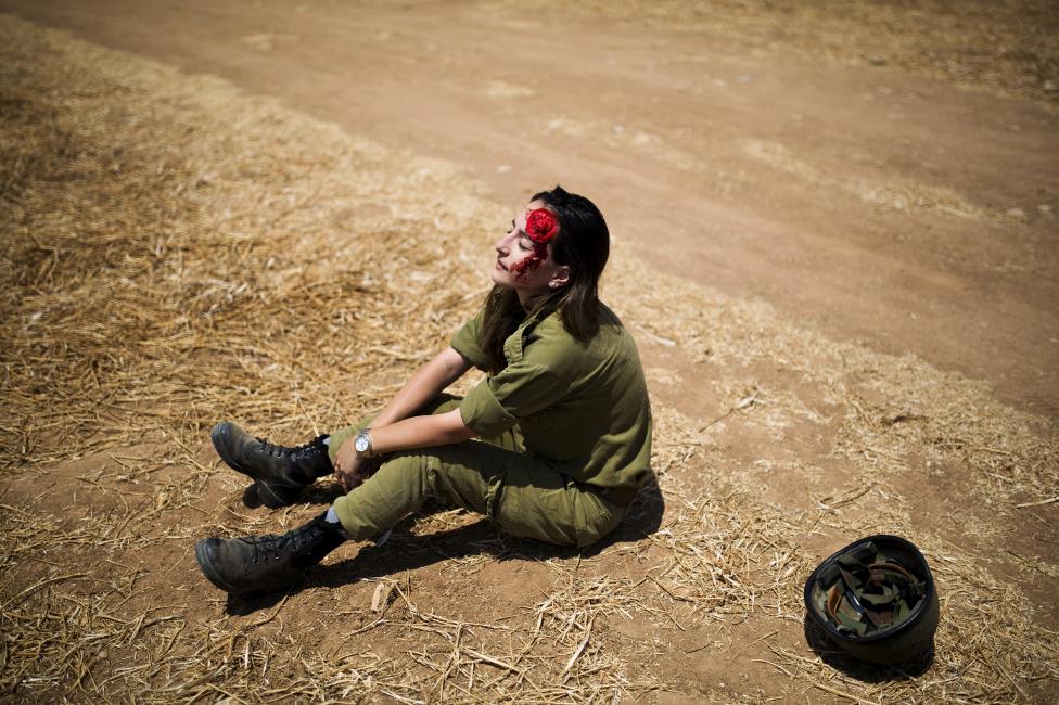 Trong hình là một nữ binh sĩ với khuôn mặt như bị thương tích và cục máu giả. Thực tế cô đang đóng làm người bị thương trong khóa huấn luyện cho binh sĩ khi bị bom tấn công ở Kiryat Gat, Israel. Nguồn ảnh: REUTERS/ Amir Cohen.