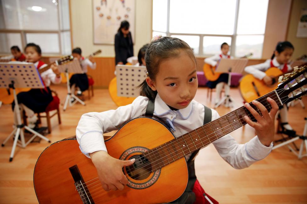 Một bé gái đang chơi ghi ta tại cung thiếu nhi Mangyongdae của thủ đô Bình Nhưỡng
