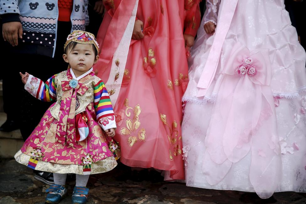 Em bé Triều Tiên trong trang phục truyền thống chụp ảnh cùng một cặp đôi mới cưới ở Bình Nhưỡng