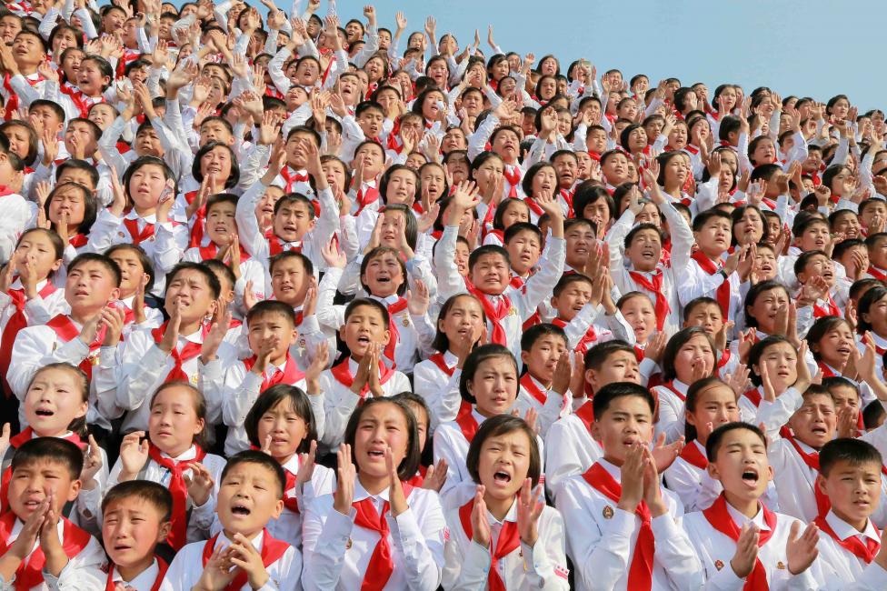 Học sinh Triều Tiên vui mừng chào đón nhà lãnh đạo Kim Jong Un đến tham dự buổi lễ mang tên 'Chúng ta hạnh phúc nhất thế giới' nhằm kỷ niệm 70 năm ngày thành lập Liên hiệp Trẻ em Triều Tiên