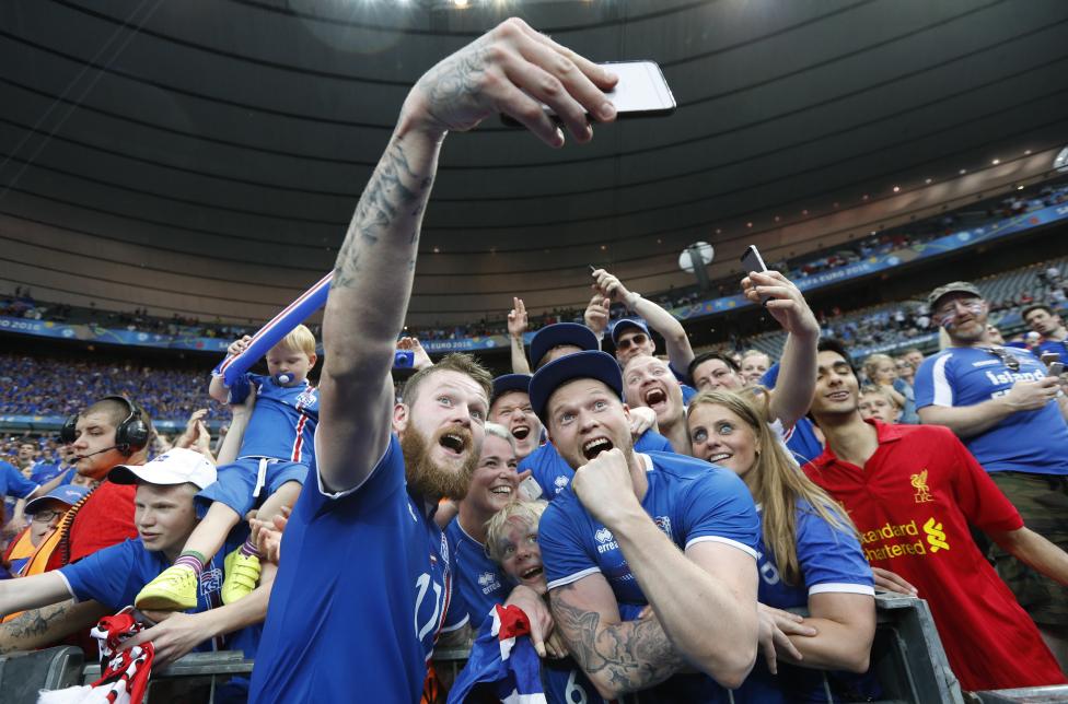 Aron Gunnarsson của đội Iceland đang ăn mừng chiến thắng cùng fan hâm mộ sau trận đấu với Áo.