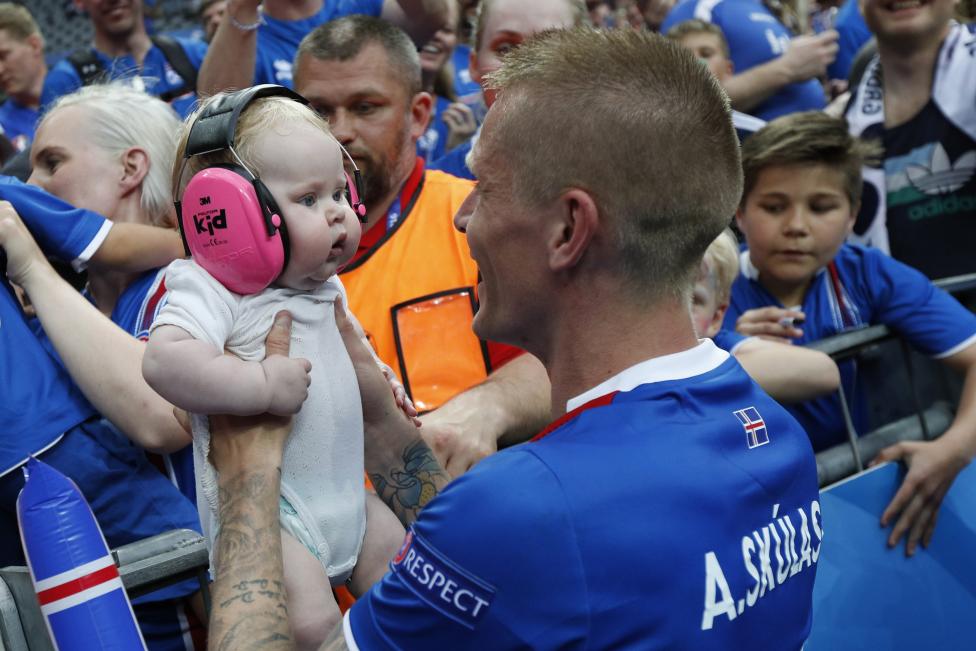 Cầu thủ Iceland Ari Skulason ăn mừng chiến thắng với một em bé sau trận đấu với Áo.