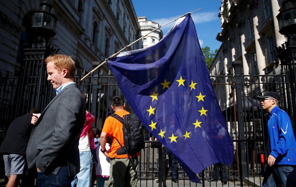 Một người đàn ông nước Anh mang trên vai lá cờ EU sau khi tuyên bố chính thức được đưa ra.