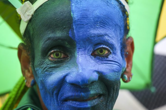 CĐV Brazil với khuôn mặt sơn xanh và đeo lens cùng màu