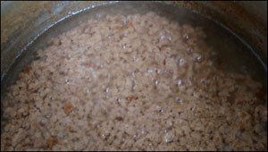 Bước 5: Sau một thời gian, dầu dừa trong dần, có lớp cặn sền sệt đọng xuống dưới, vẫn để lửa nhỏ cho nước dừa sôi nhẹ.