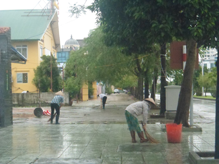 Các hộ dân hai bên đường quét dọn vệ sinh sau bão.