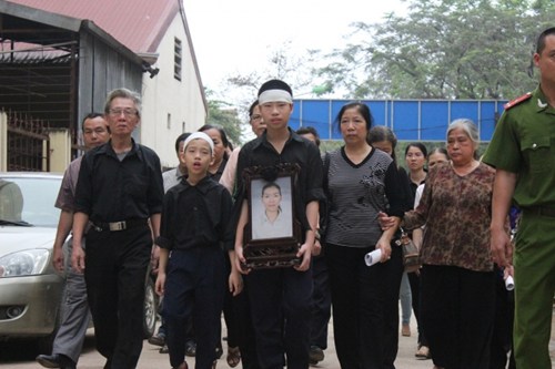 Hai con trai của chị Huyền ôm di ảnh của mẹ đến tham dự phiên tòa, đi cùng là những người thân trong gia đình.