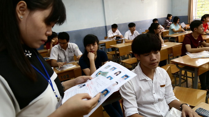 Tại điểm thi trường THPT Bùi Thị Xuân, giám thị kiểm tra giấy tờ cá nhân của thí sinh dự thi vào trường đại học Kinh tế TP.HCM trước khi làm bài thi môn toán