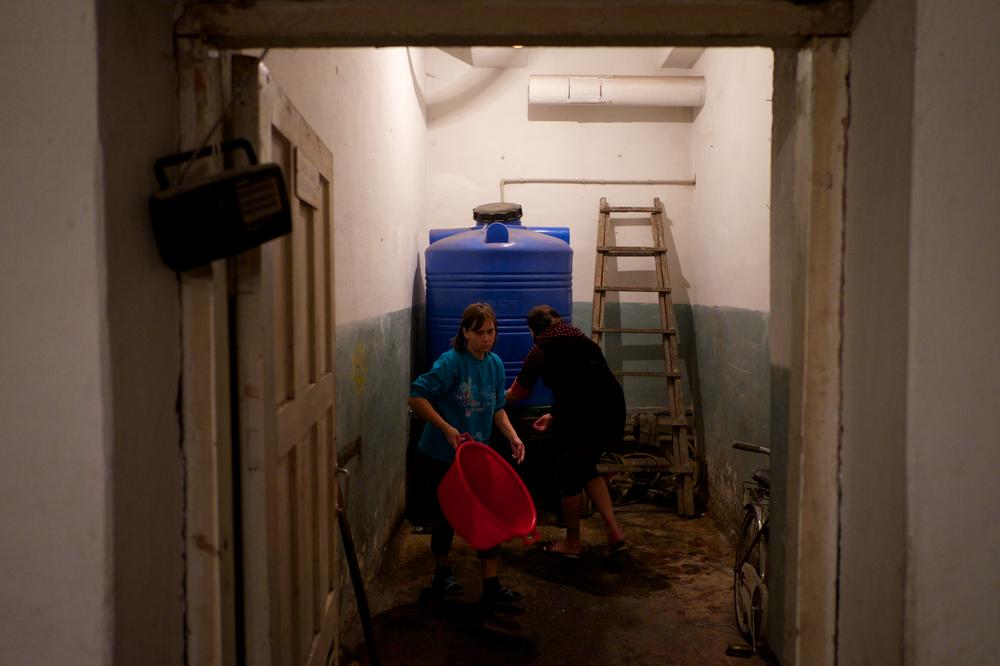 Người dân tản cư lấy nước dự trữ từ trong hầm tránh bom từ thời Xô viết ở Petrovskiy, phần lớn trong số họ bày tỏ nỗi lo sợ về những ngày sắp tới khi mùa đông khắc nghiệt đang đến gần