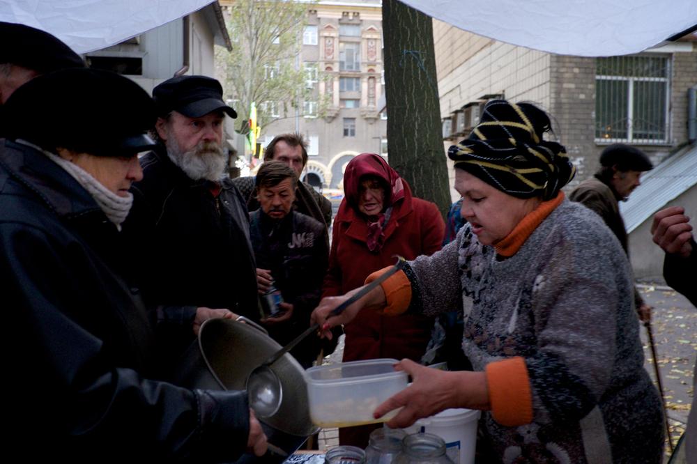 Một tình nguyện viên phát thức ăn cho những người khốn khó ở trung tâm thành phố Donetsk