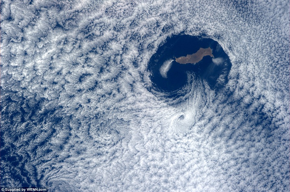 Một quốc gia nhỏ bé được quan sát từ trên trạm vũ trụ quốc tế bởi một khoảng trống được hình thành bởi những đám mây