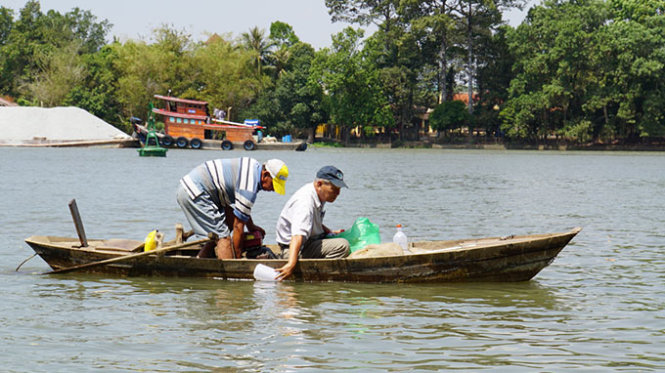 Nhà nghiên cứu Phạm Văn Miên lấy mẫu nước trên sông Đồng Nai để xem xét chất lượng sau khi có dự án lấn sông