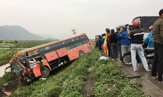 Chiếc xe khách bị lao xuống ruộng ở vệ đường sau va chạm mạnh. Ảnh: Gia đình và Xã hội Chiếc xe khách bị lao xuống ruộng ở vệ đường sau va chạm mạnh. Ảnh: Gia đình và Xã hội