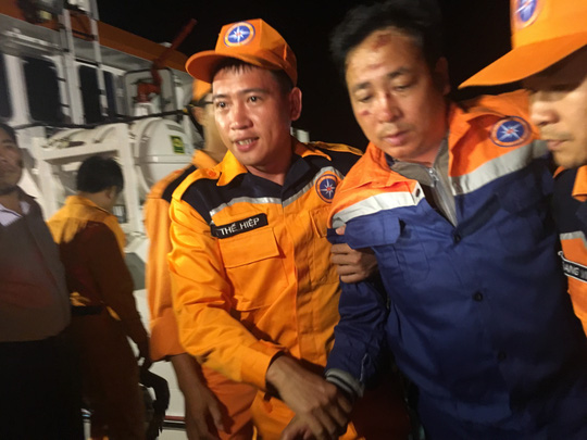  Thuyền trưởng tàu Hải Thành 26-BLC Nguyễn Viết Thắng (thứ 2 từ phải sang) được đưa lên xe cứu thương Ảnh: Người Lao động