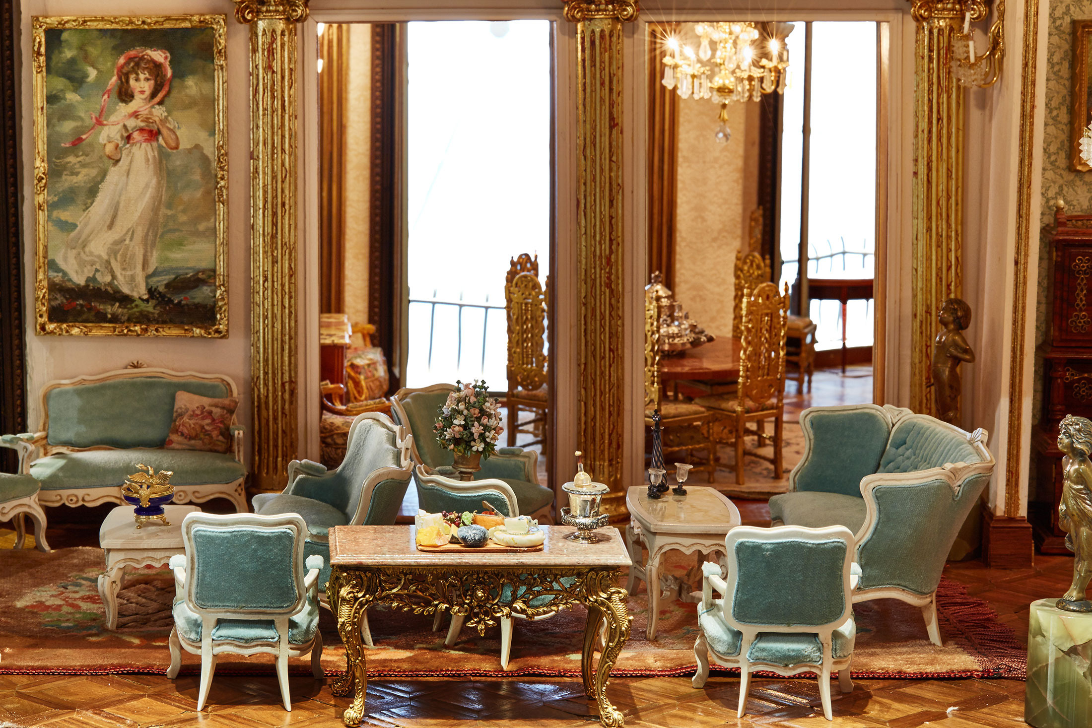Bộ salon tuyệt đẹp màu xanh được bày biện trên một tấm thảm khâu tay, bên cạnh là lọ hoa bằng ngọc lưu ly và bức tranh sơn dầu mang phong cách của thế kỷ 18.