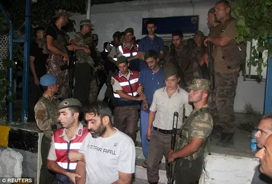 11 lính biệt động Thổ Nhĩ Kỳ bị lột trần, còng tay, trên mặt có nhiều vết cắt và bầm tím trong khi được giải đi bằng xe
