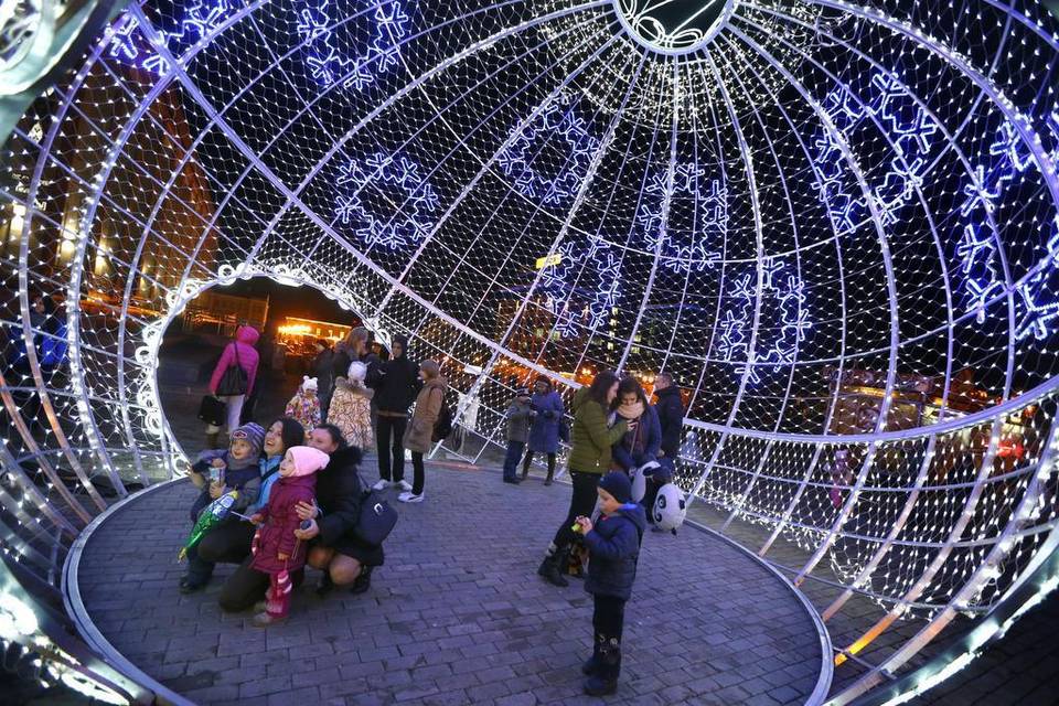 Người dân chụp ảnh lưu niệm bên trong quả cầu Giáng sinh khổng lồ tại Minsk, Belarus. Ảnh Sergei Grits/AP