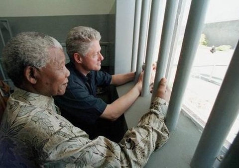 Tổng thống Nam Phi và người đồng cấp Mỹ Bill Clinton nhìn ra từ phòng giam số 5, khu vực B của nhà tù trên đảo Robben, Nam Phi hôm 27/3/1998. Ảnh: AP