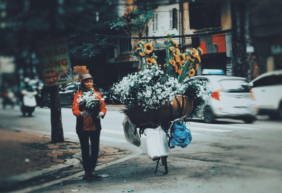 Người phụ nữ bán hoa dạo vẫn dậy từ sớm đi lấy hàng rồi đưa hoa tươi đi bán dọc phố trong mưa. Ảnh Sưu tầm Người phụ nữ bán hoa dạo vẫn dậy từ sớm đi lấy hàng rồi đưa hoa tươi đi bán dọc phố trong mưa. Ảnh Sưu tầm