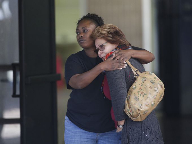 Hai người phụ nữ động viên nhau khi các gia đình tập trung tại Trung tâm Cộng đồng Rudy Hernandez để đón người thân thoát chết trong vụ xả súng. 