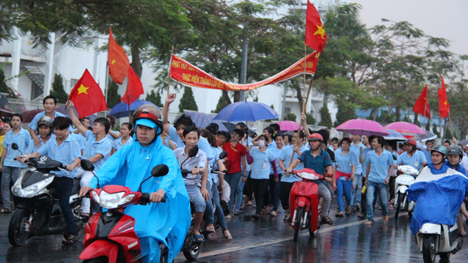 Công nhân Bình Dương diễu hành phản đối Trung Quốc trong cơn mưa chiều 12-5 - Ảnh: Bá Sơn