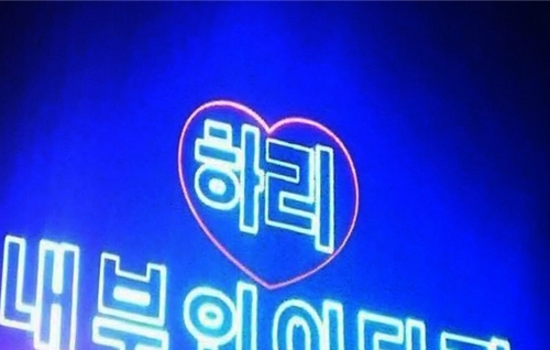 Màn hình đèn led trong quán bar chạy chữ tiếng Hàn: ''Hari, làm vợ anh nhé!''. Sau khi nói lời yêu thương với người yêu, cả hai hôn nhau say đắm.