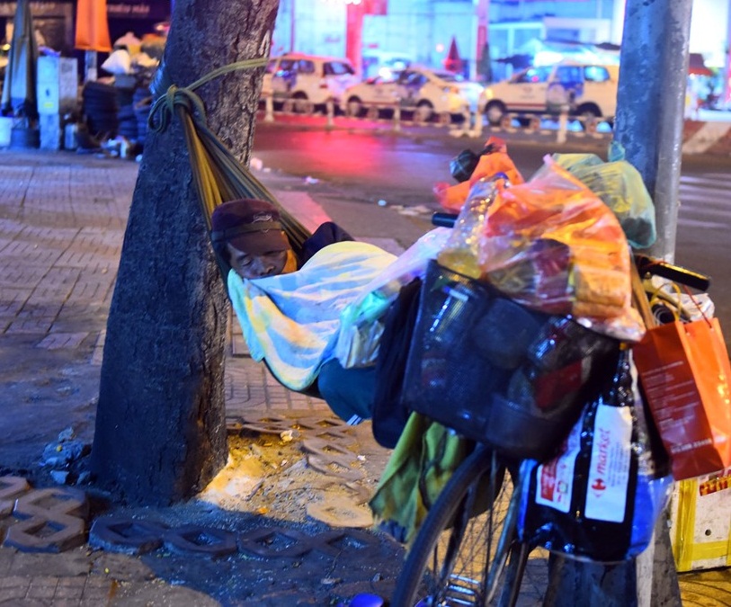 Đêm 30 Tết, thời tiết Sài Gòn se lạnh (22 độ C). Những người dân không có nhà cửa cố thu mình trong chiếc áo mỏng dính cho đỡ lạnh chợp mắt qua đêm. Ảnh: Zing News