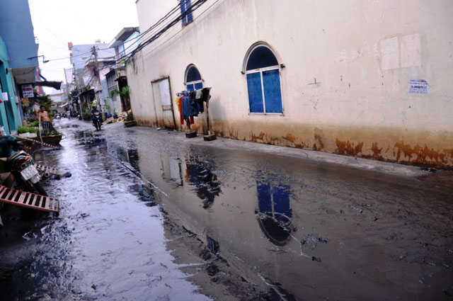 Sau nước rút, bùn đen ngòm đóng thành từng lớp trên mặt đường kèm theo đủ thứ rác thải. Ảnh Dân Việt