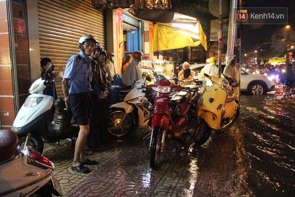 Nhiều người đi đường phải dừng lại trú mưa dưới hiên nhà dân
