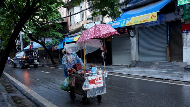 Người phụ nữ vẫn mưu sinh trong mưa lạnh giữa Thủ đô. Ảnh Sưu tầm Người phụ nữ vẫn mưu sinh trong mưa lạnh giữa Thủ đô. Ảnh Sưu tầm