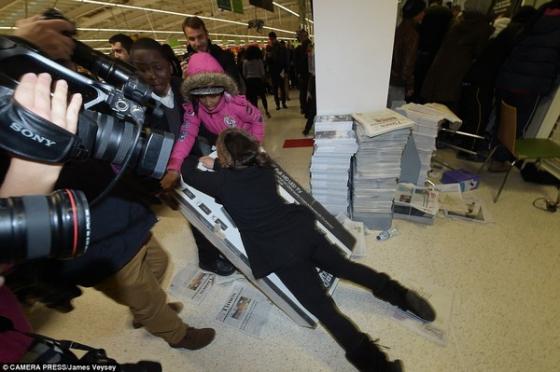 Một cảnh tượng gây sốc: Một phụ nữ cố gắng nằm đè lên chiếc ti vi sau khi cãi nhau tranh giành chiếc ti vi này với những khách hàng khác tại 1 cửa hàng Asda ở Wembley.