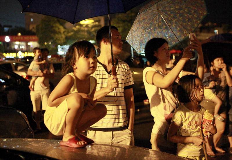 Dù trời mưa to nhưng người dân vẫn đội ô, mặc áo mưa đứng xem bắn pháo hoa ở sân vận động Mỹ Đình. 