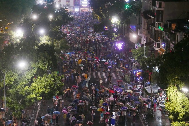 Bất chấp thời tiết không thuận lợi, hàng nghìn người dân thủ đô đội mưa, đứng quanh hồ Hoàn Kiếm, đường Đinh Tiên Hoàng, quảng trường Đông Kinh Nghĩa Thục để ngắm pháo hoa.