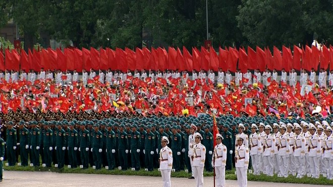 Từng đoàn quân đứng nghiêm trang dưới lá cờ Tổ quốc trên nền nhạc Tiến quân ca