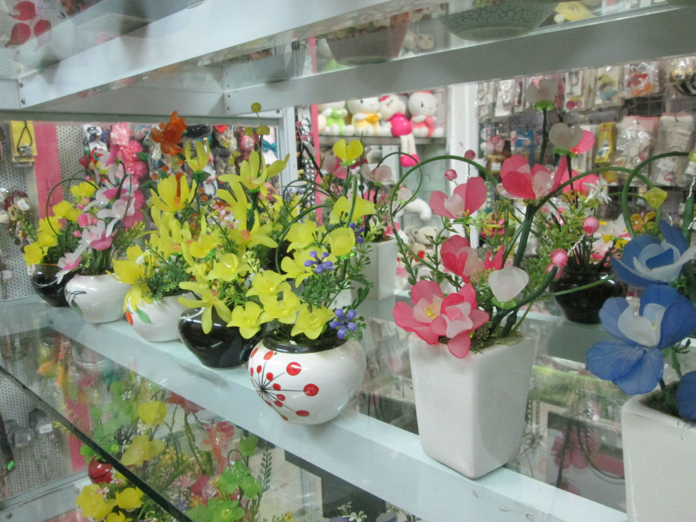 Những bình hoa, lọ hoa đá có giá từ 50 ngàn tới 200 ngàn, sản phẩm mới xuất hiện năm nay. Những lọ hoa này nguồn gốc nguyên liệu từ Trung Quốc. Khi được nhập về Việt Nam, những cánh hoa được xâu chuỗi lại, đi kèm với những cành lá, cành nụ bằng nhựa... tạo thành những chiếc lọ hoa đủ sắc màu