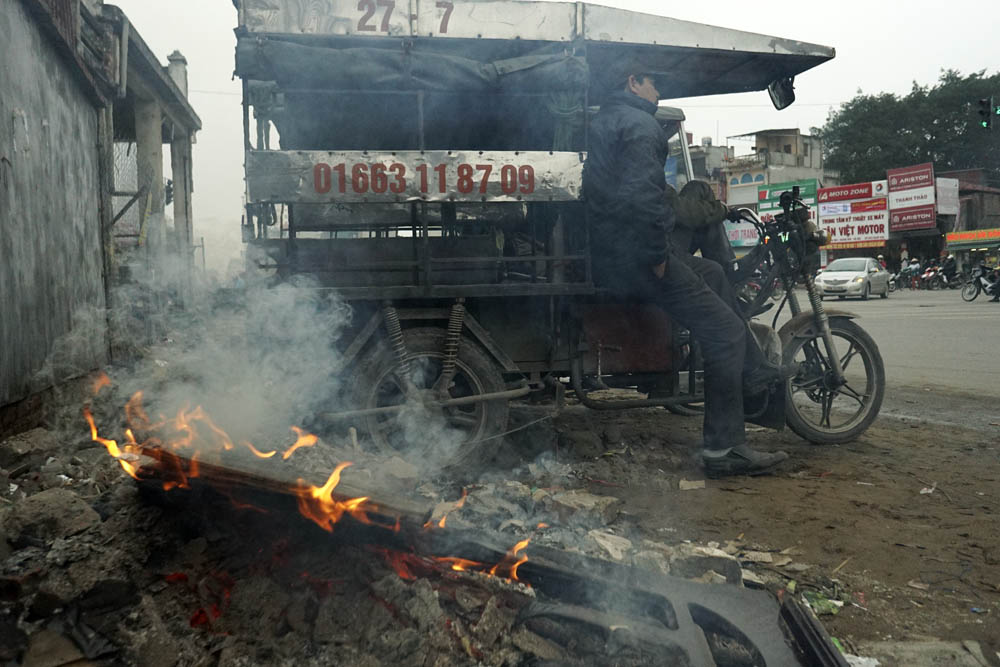 Nhiều người thường xuyên làm việc ngoài đường đã phải tìm cách chống chọi với đợt rét này. Ảnh: Dân Trí