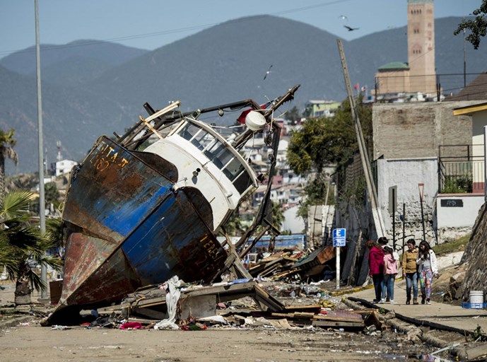 Theo tờ The Guardian, do tác động của động đất, bờ biển Coquimbo đã hứng chịu những trận sóng thần cao đến 4,5 m, gây thiệt hại nghiêm trọng cho các cảng, nhà cửa và đường phố. Nhiều tàu đánh cá lớn bị sóng cuốn khỏi cầu cảng nằm chỏng chơ trên phố. Ảnh: AFP