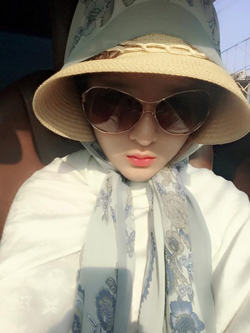 Lily Luta diện style như bà cụ ngay cả khi ngồi trên xe. Cô tận dụng cả áo khoác, khăn choàng, nón rộng vành và kính râm để bảo vệ toàn thân.