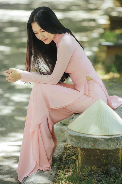 Chiếc áo dài màu hồng phấn mềm mại, tôn lên nét duyên dáng của người phụ nữ Việt.