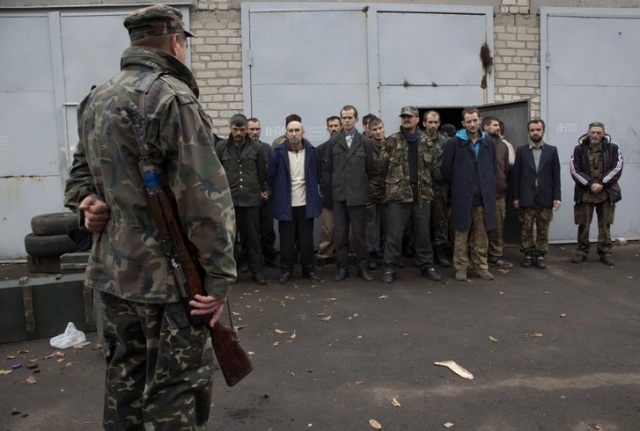 Một tay súng của quân ly khai thân Nga canh giữ tù binh chiến tranh Ukraine tại thị trấn Illovaysk, miền đông Ukraine