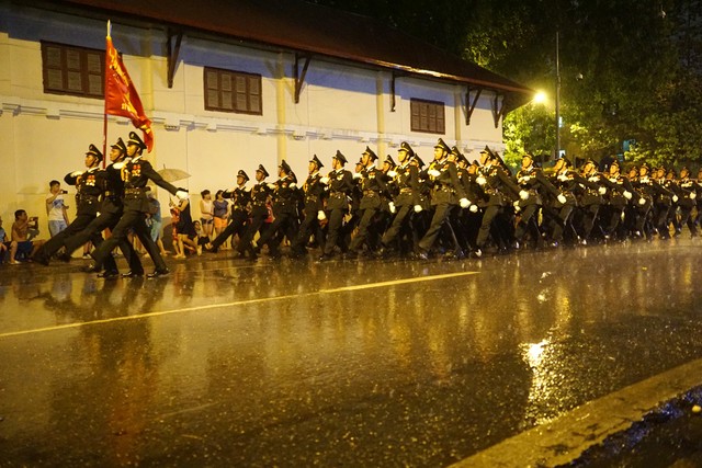 Đến khoảng 9 giờ, bất ngờ cơn mưa lớn đổ ập xuống đường phố nhưng đoàn diễu hành vẫn tiếp tục trong mưa. Ảnh Dân Trí