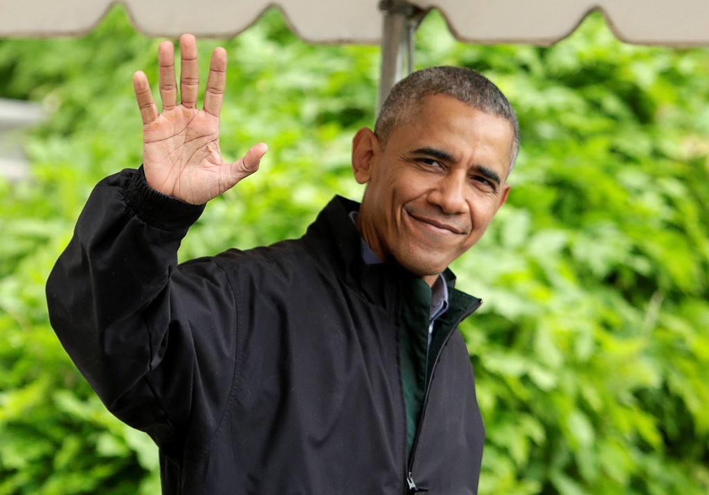 Tổng thống Obama vẫy chào các phóng viên trước khi lên đường. Ảnh: Reuters