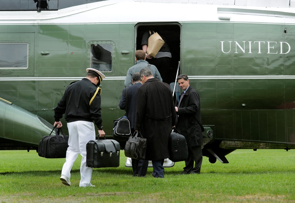 Các trợ lý xách vali hạt nhân của Tổng thống Mỹ cùng lên trực thăng Marine One. Ảnh: Reuters